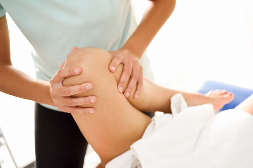 Der Spezialist führt die therapeutische Massage mit Arthrose des Knies durch